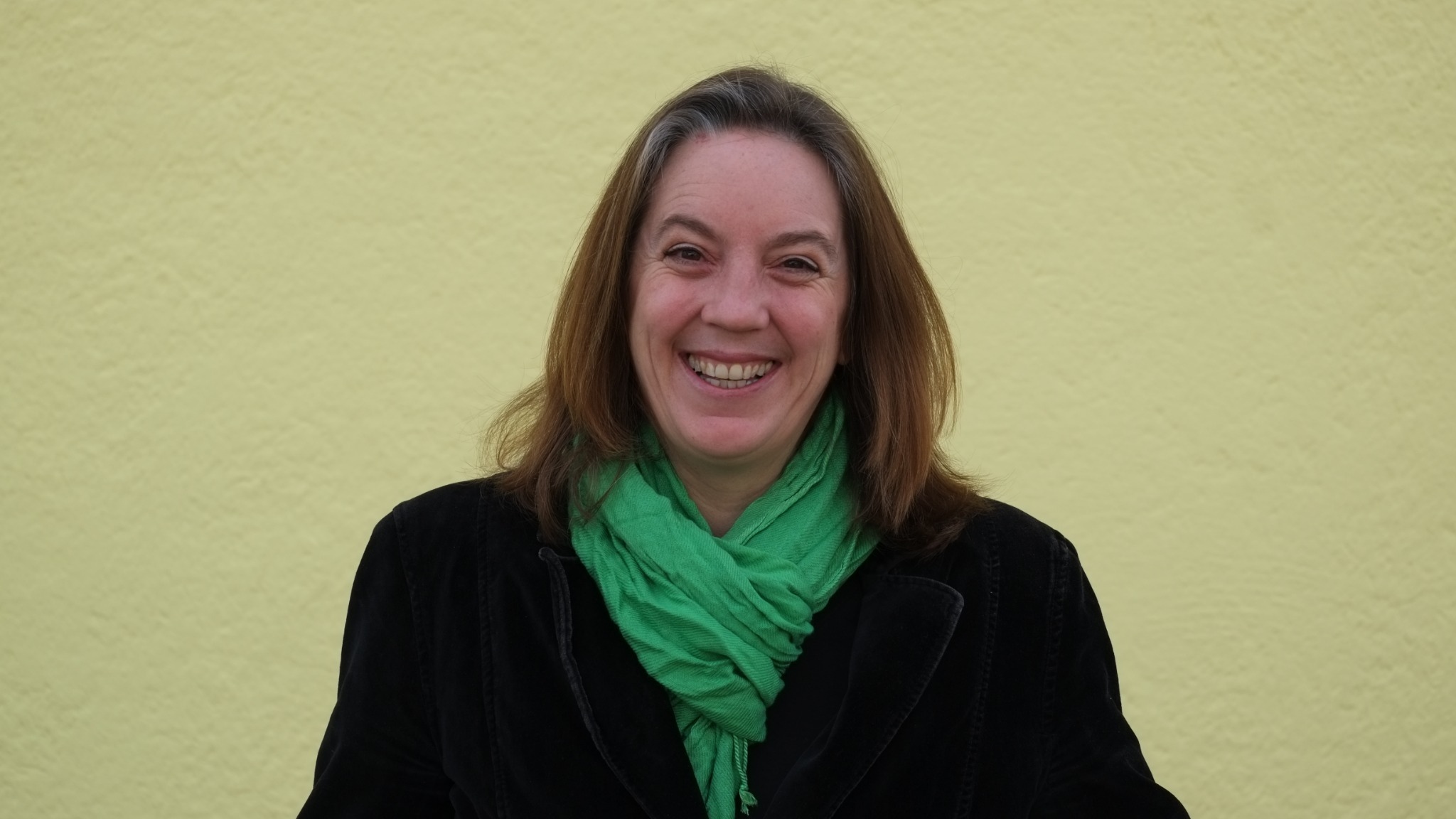 Hannah Nitschinger smiling, wearing a bright green scarf
